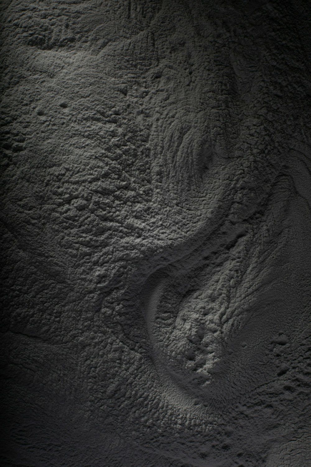 Hyper-light-Carbon- Prosilas- Stampa 3D - 3D Printing L'immagine è probabilmente di Hyper-light-Carbon, un materiale per stampa 3D leggero e resistente sviluppato da Prosilas. La polvere viene utilizzata per creare oggetti mediante stampa 3D SLS (Selective Laser Sintering). Un mucchio di polvere Hyper-light-Carbon nera su uno sfondo nero.